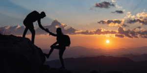 Two people climbing a mountain